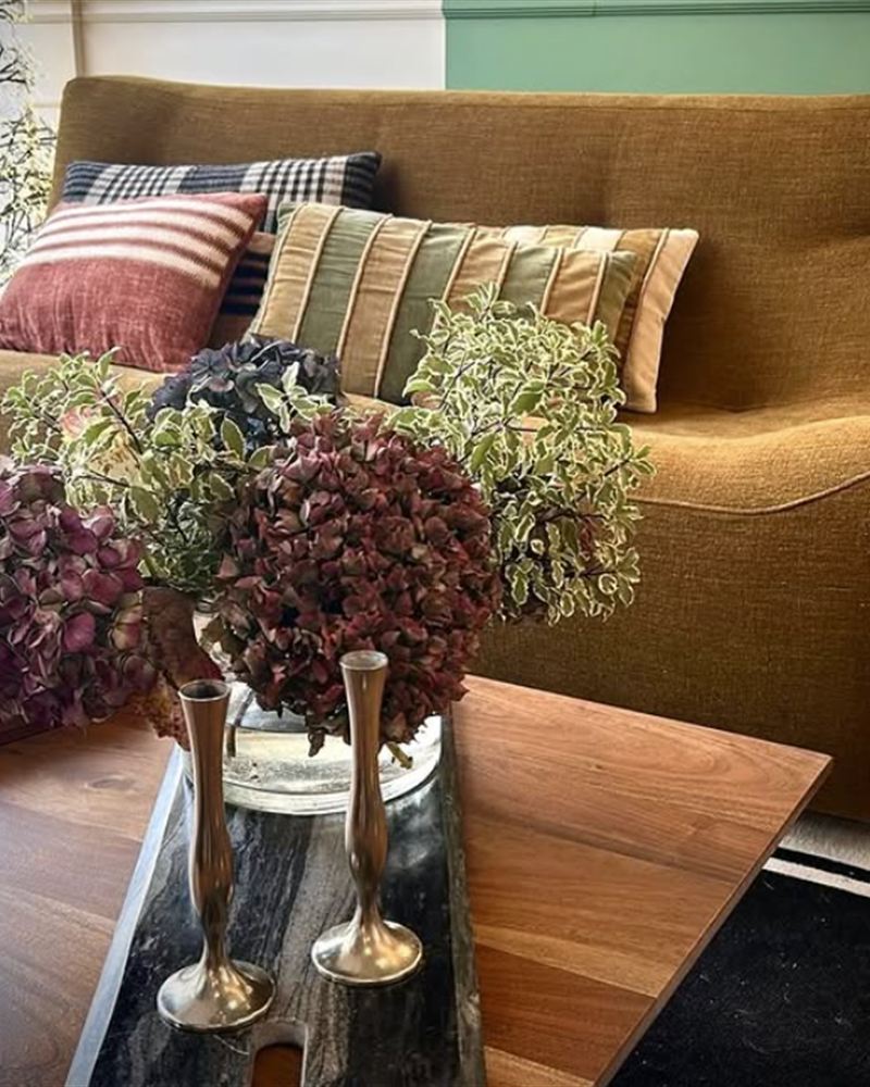 Salon chaleureux, canapé camel et hortensias séchés